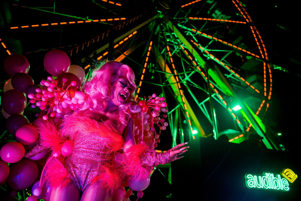 A drag queen dances at the afterhours party underneath a Ferris wheel at the Audible Experience, one of the best moments of SXSW 2024.