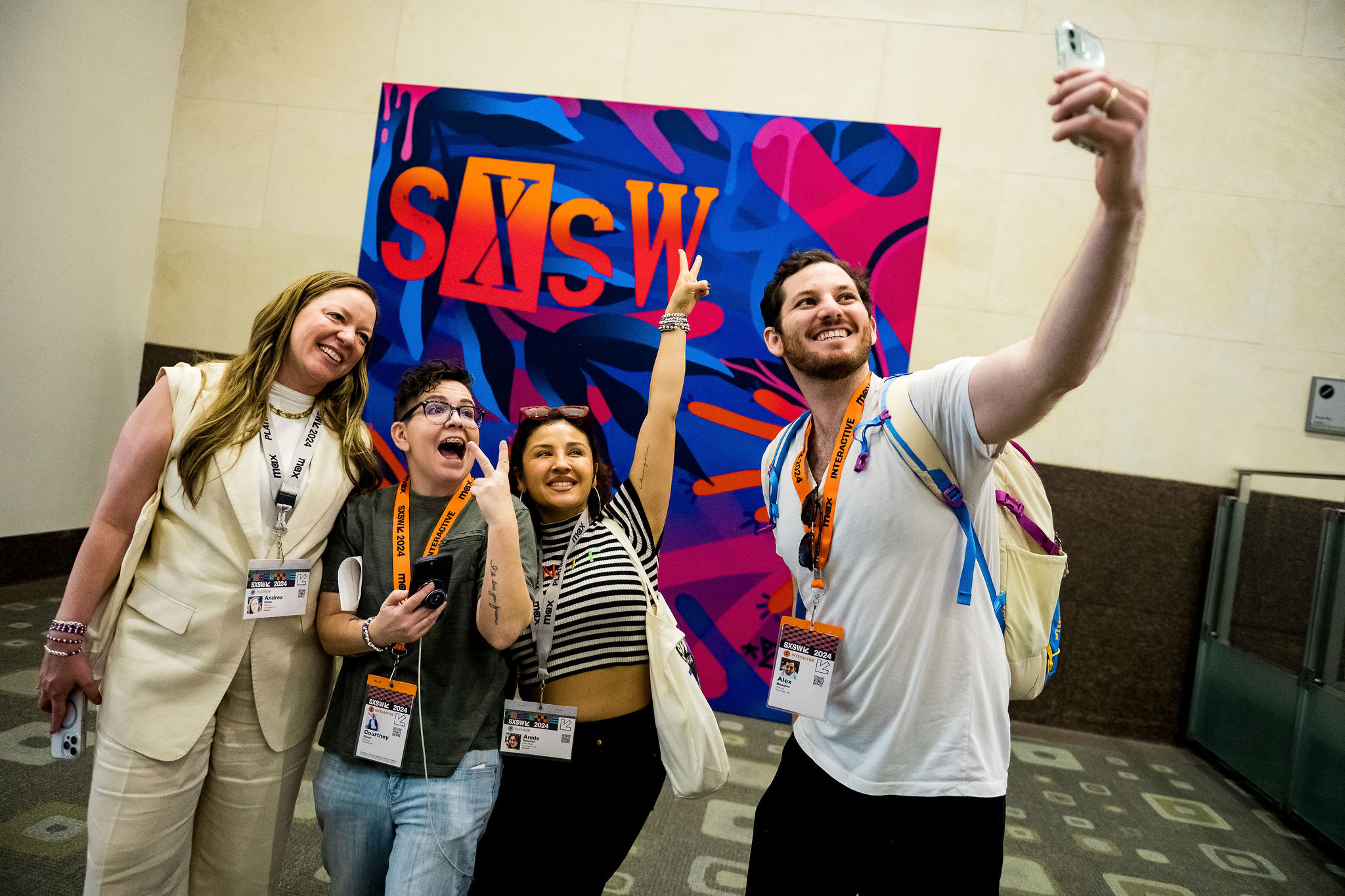 Attendees take a selfie in front of the 2024 SXSW mural.