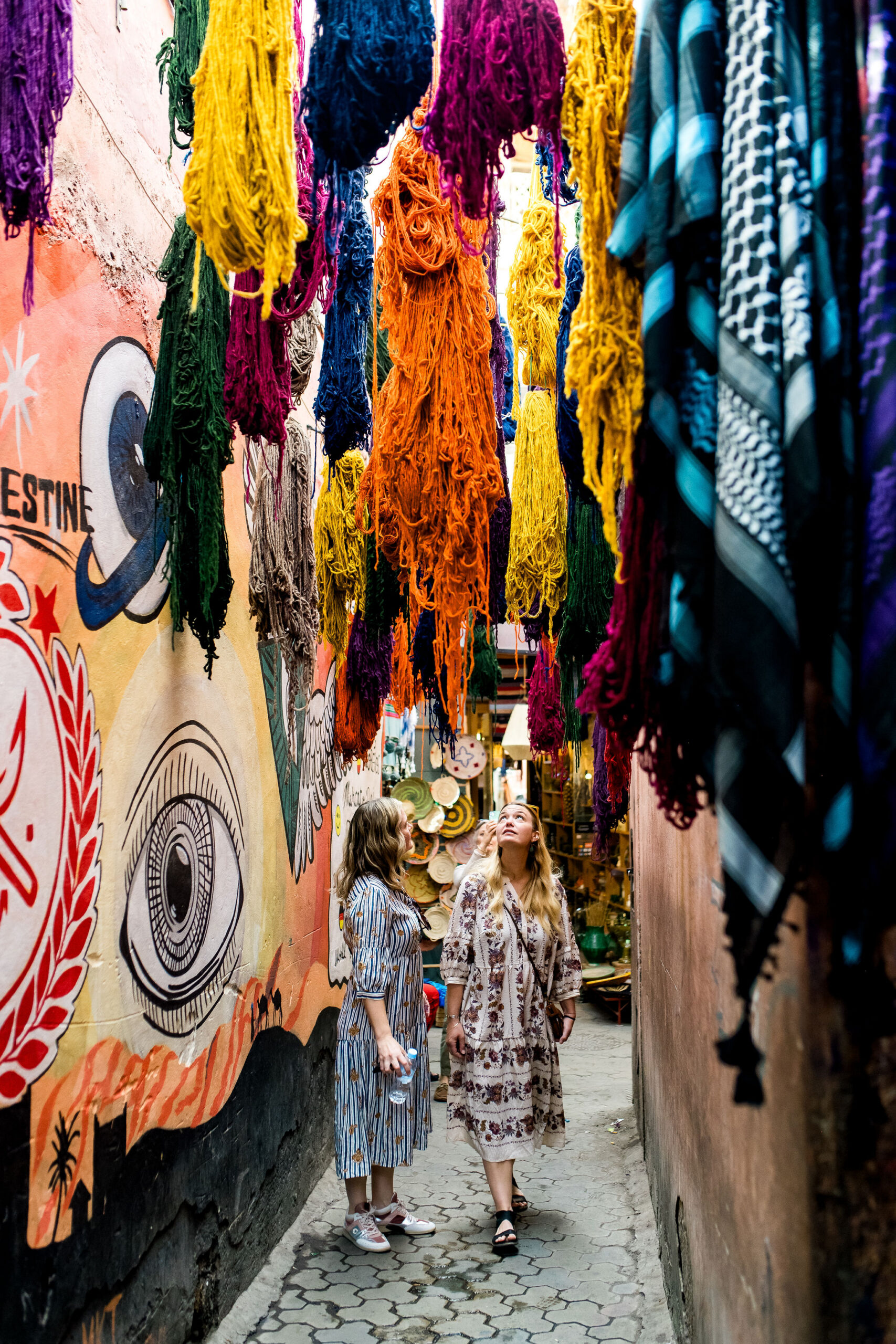 Women stare at a wall of yarn